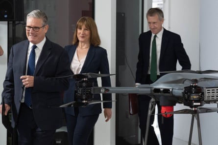Starmer, Reeves and Jarvis walking out in a line past a drone