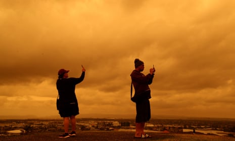 People photograph the smoke- coloured sky over Manukau, south Auckland