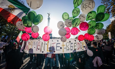 Demonstrators in Berlin hold a banner reading ‘Woman, Life, Freedom’ and balloons in the colours of the Iranian flag against a backdrop of the city’s Victory Column, in solidarity with Iranian protests after the death of Mahsa Amini.