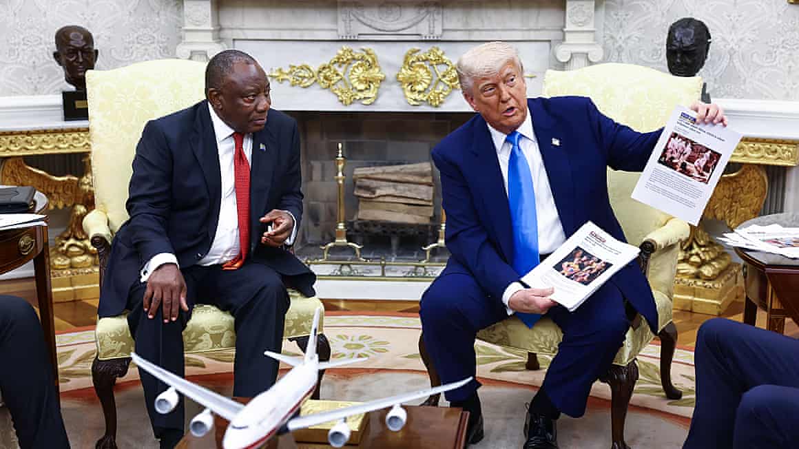 President Ramaphosa sat next to Donald Trump at the White House as Trump holds up printed out pieces of paper with images on them