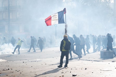 Protesters with gas masks, some wearing yellow vests, on a smoke-filled public square with the French flag in the centre.