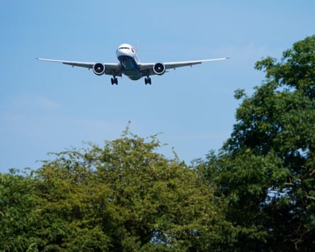 A plane coming in to land over trees