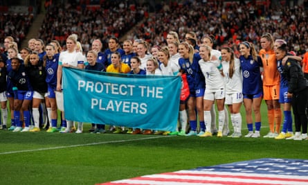 The USA and England players show a ‘Protect the Players’ banner before kick-off
