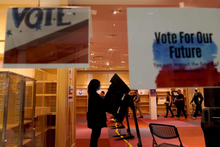 A woman casts her ballot on the first day of early voting in a recently-shuttered store at Oak Park Mall in Overland Park, Kansas, on 17 October.