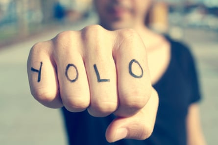 closeup of a young man with the word yolo on his fist