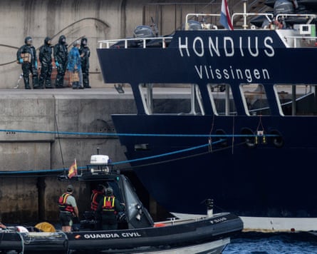 Medical staff in protective clothing wait for passengers to disembark from the MV Hondius in Tenerife.