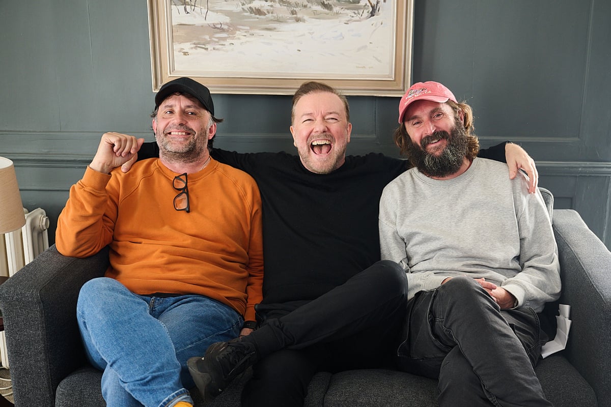 Three men sitting on a sofa laughing