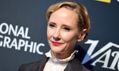 Anne Heche, pictured in 2018, wearing bright red lipstick, a black jacket and white frilly shirt