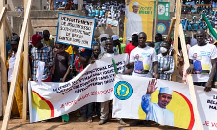 People at an election rally carry banners with photographs of the transitional leader