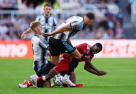 Liverpool's Alexander Isak gets clattered by Newcastle United's Lewis Hall and Sven Botman.