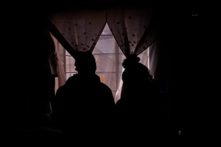 Silhouettes of two women in a darkened room