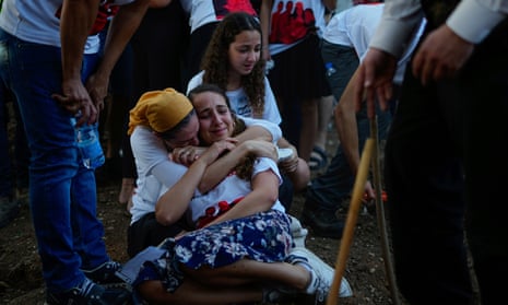 Mourners gather around the graves of British-Israelis Lianne Sharabi and her two daughters, Noiya,16, and Yahel,13, during their funeral in Kfar Harif, Israel on 25 October.