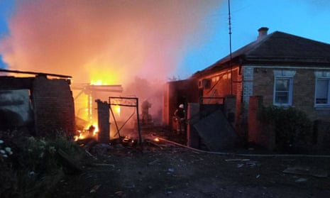 Firefighters work on a blaze at a home in the village of Sobolevka, Belgorod region