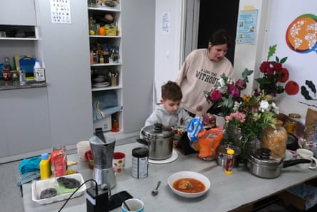 Tetiana Kharkivska serves stew to her seven-year-old son, Roman, in temporary housing for displaced people in Bucha.