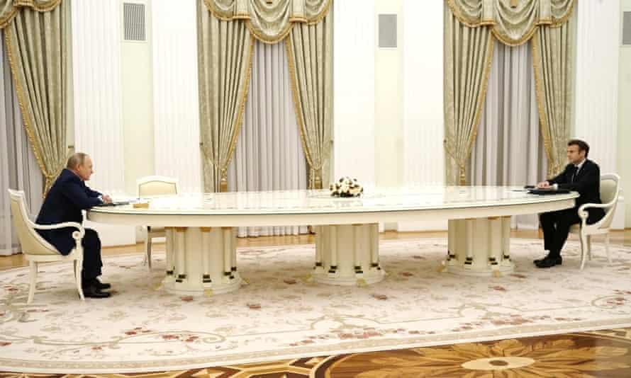 Emmanuel Macron, right, and Vladimir Putin talk across a long table in the Kremlin