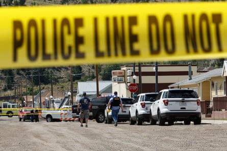 police officers walking on street behind yellow caution tape