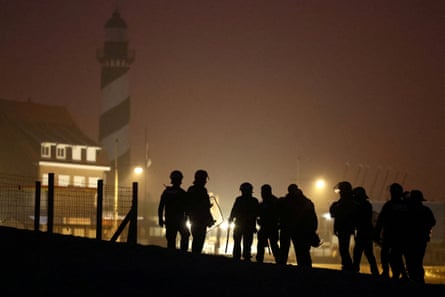 Police officers stand guard on the beach in Petit-Fort-Philippe, Gravelines, near Calais.