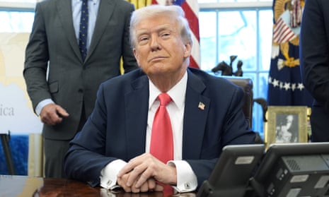 Donald Trump signs an executive order in the Oval Office of the White House in Washington on 25 February 2025.