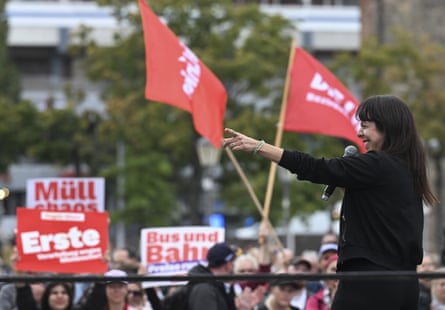 Elif Eralp points to the crowd who hold flags and banners at an election campaign event in Berlin