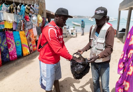 A vendor puts clothes in a single-use plastic bag in Ngor village in Dakar, Senegal