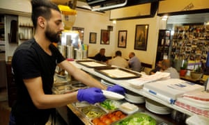 A worker prepares food for customers at a restaurant as Palestinians ease Covid-19 restrictions in Jenin.