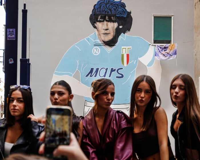 Maradona mural poses and a piglet race: photos of the day – Wednesday