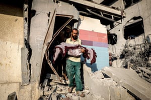 The body of a Palestinian girl is carried out of a badly damaged building