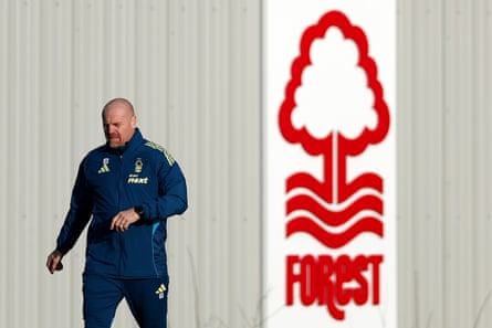 Sean Dyche in a Forest tracksuit next to a large club logo at the Nigel Doughty Academy