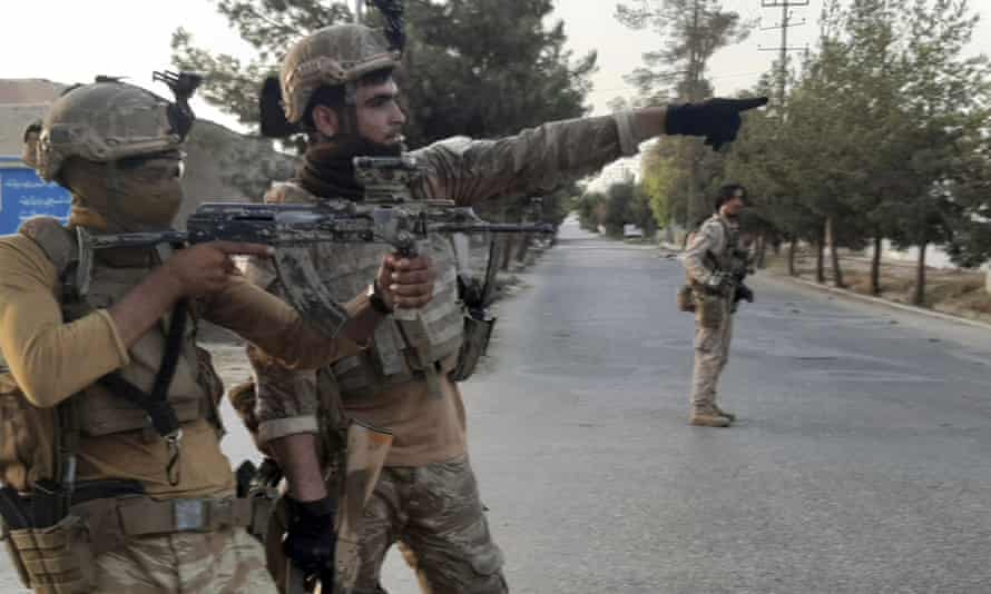 Afghan special forces patrol a deserted street during fighting with Taliban fighters in Lashkar Gah.