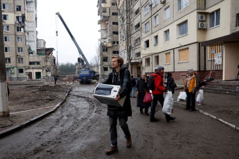 A man leaves his destroyed apartment after retrieving some belongings in Dnipro.