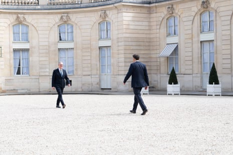 Keir Starmer and Emmanuel Macron walking towards each other.