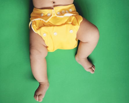 Baby wearing a yellow cloth nappy