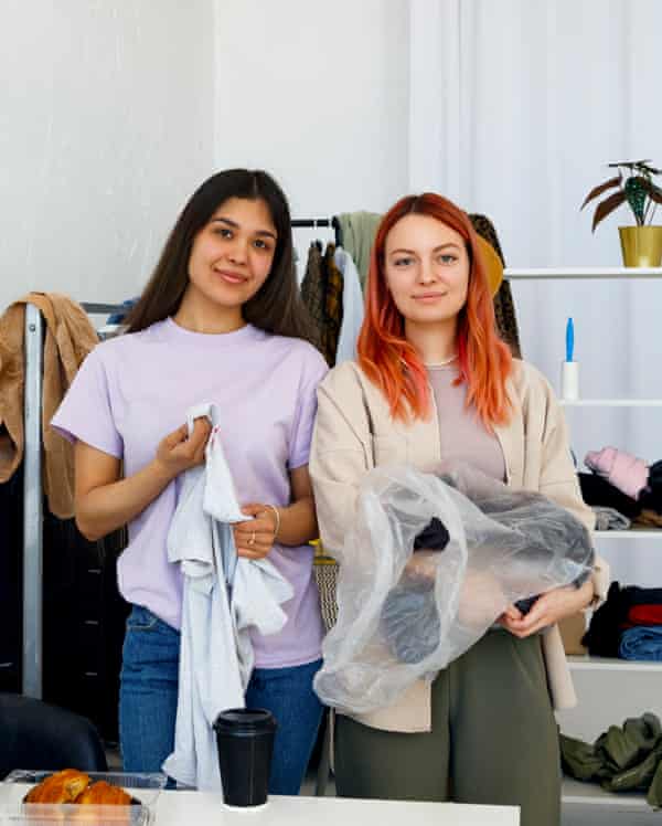 Young Businesswomen In New Fashion StoreOptimistic young female small business owners unpacking clothes while organizing new collection in modern fashion shop