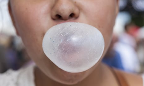 child blows bubble with gum. only the lower half of the kid's face is in the frame