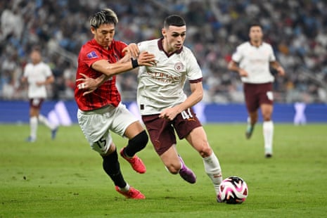 Phil Foden of Manchester City is challenged by Takahiro Akimoto of Urawa Red.