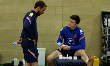 Harry Maguire gets treatment for his ankle injury as Gareth Southgate watches on.
