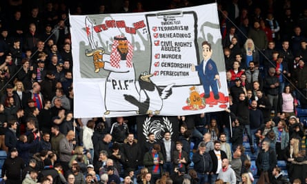 Crystal Palace fans unfurl a banner protesting the Saudi-backed takeover of their opponents.
