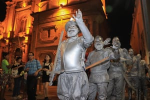 Men dressed in period military costumes sprayed silver