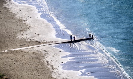 People walk on Lyall Bay beach on Easter Monday during lockdown for the Coronvirus outbreak