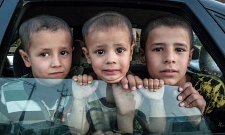 Kids look out of a car inside an all-Christian refugee camp in Erbil, Iraq. 