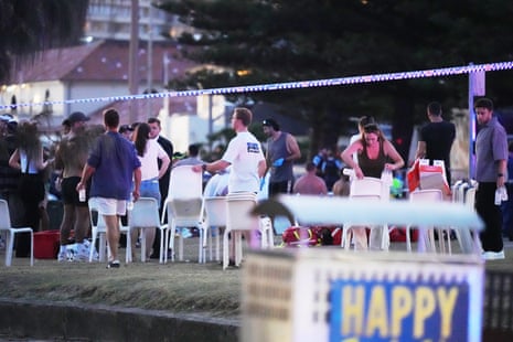People and emergency workers gather Bondi Beach after the shooting