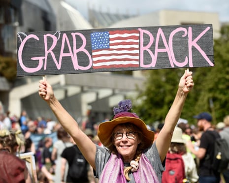 protestor with a sign reading 'Grab America back'