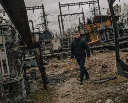 Man walking past wrecked structures in the substation