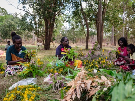 Artists and Bula’bula Arts staff prepare floral decorations to mark the runway through the park ahead of the Ramingining Fashion Parade. Photographed by Alana Holmberg on 25 June 2026. Northern Territory, Australia.