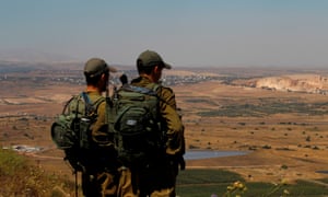 Israeli soldiers at an army base in the Golan Heights look out across the south-western Syrian province of Quneitra.