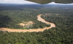 Muddy coloured river running through dense green forest