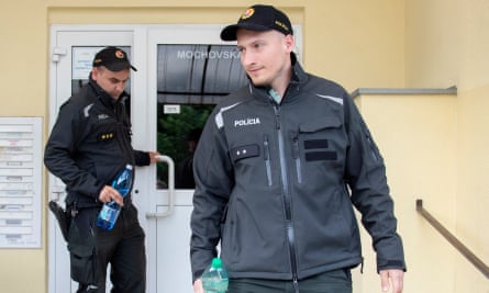 Two police officers leave the apartment block