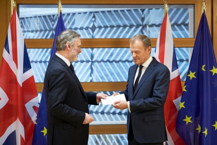 The British ambassador to the EU, Tim Barrow, left, hands the Brexit letter to Donald Tusk, the European council president, in Brussels.