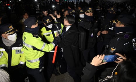 Polis, meclis binasına girmeye çalışan insanlarla boğuşuyor.