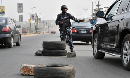 A police officer stops a car at a check point in Awka in Anambra State, south-east Nigeria.